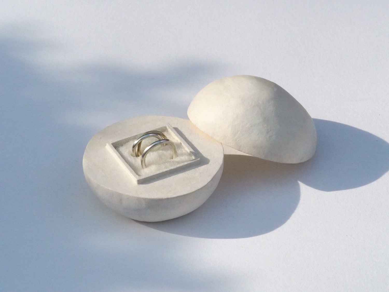 Wedding rings in a handmade paper ring box